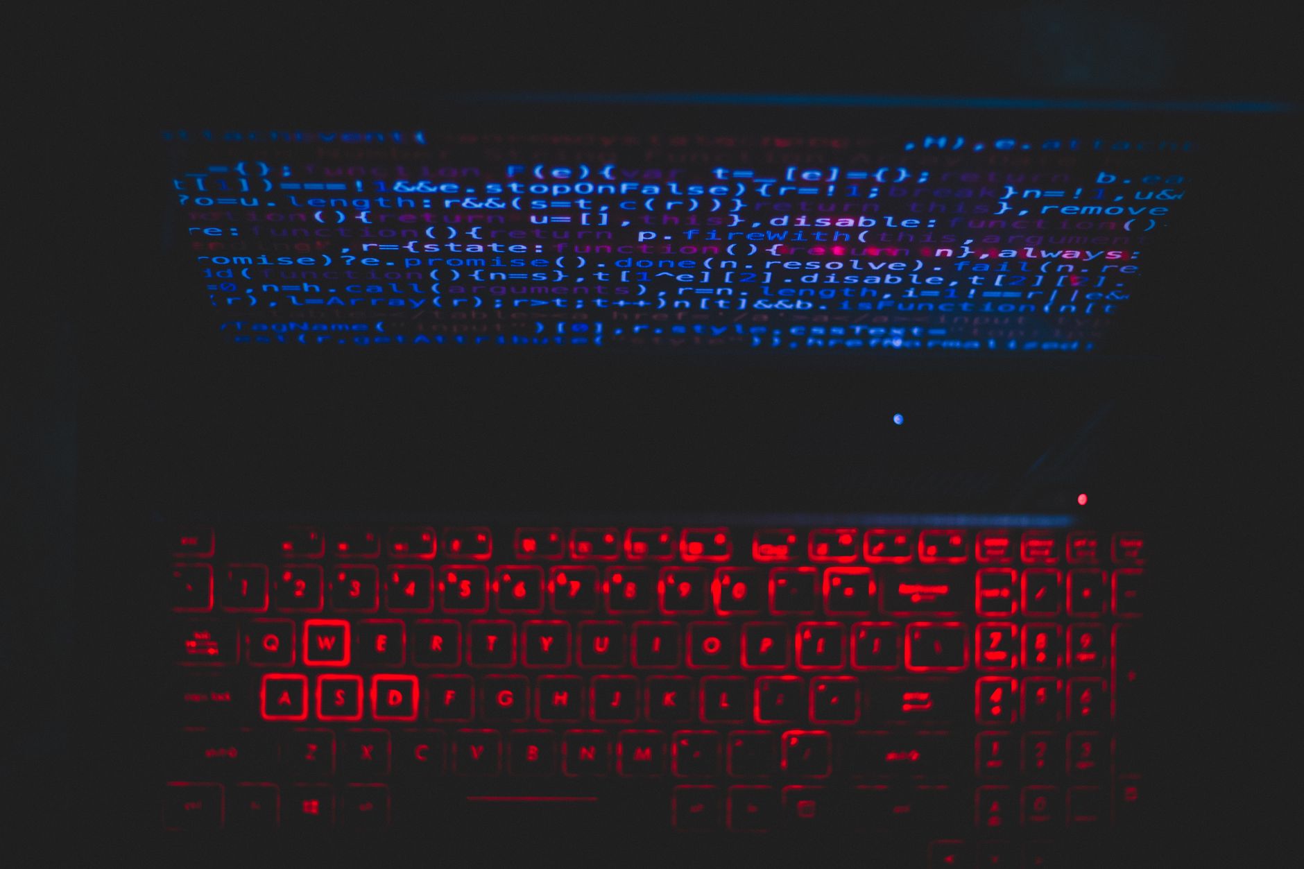 Anonymous hacker at laptop screen illustrating voter data profiling used in UK political party voter data micro-targeting